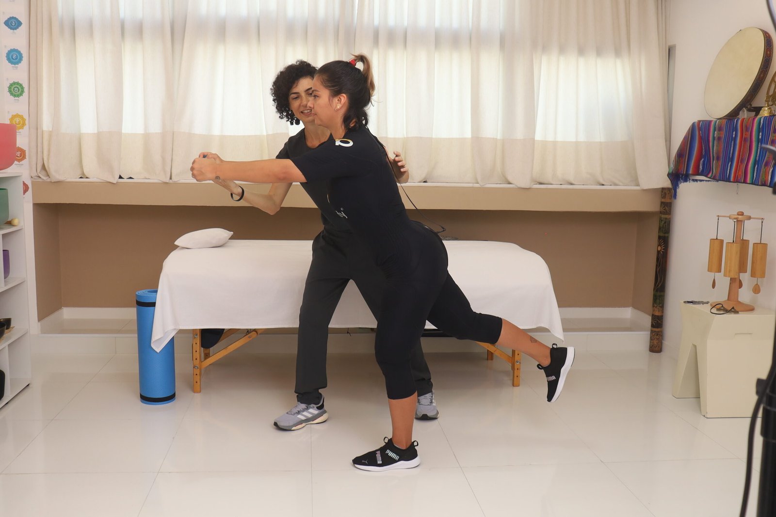 Dra. Alba Comin orientando uma paciente durante atendimento de fisioterapia com EMS-WB (eletroestimulação de corpo inteiro) em Salvador.
