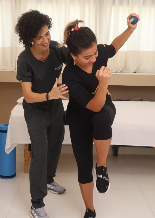 Dra. Alba Comin orienta exercício de equilíbrio com paciente usando traje de EMS-WB (eletroestimulação de corpo inteiro).